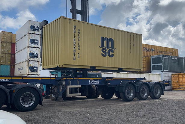 Shipping container being picked up from depot