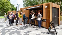 Converted ice cream kiosk with cladding and serving hatch