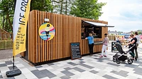 Converted ice cream kiosk with cladding and serving hatch