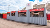 Shipping container fan zone bars with bespoke signage and serving hatches