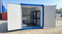 Bespoke shipping container workshop with doors open, and work bench and chemical storage cage inside