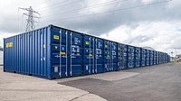Self storage site with blue shipping containers in a long row