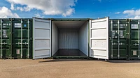 A row of shipping containers at a self storage site, with the doors of the centre unit open