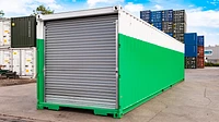 Shipping container with custom green and white paint and a large roller shutter door at the end
