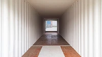 Tunnel container interior with a large roller shutter at the end