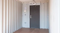 Shipping container interior with personnel door at end
