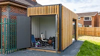 Cladded container with storage