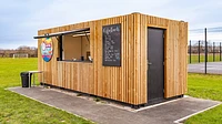 Converted refreshments kiosk with cladding and serving hatch
