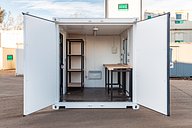 Container workshop conversion with shelves and workbench