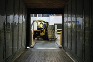 man loading goods into a lorry on a forklift